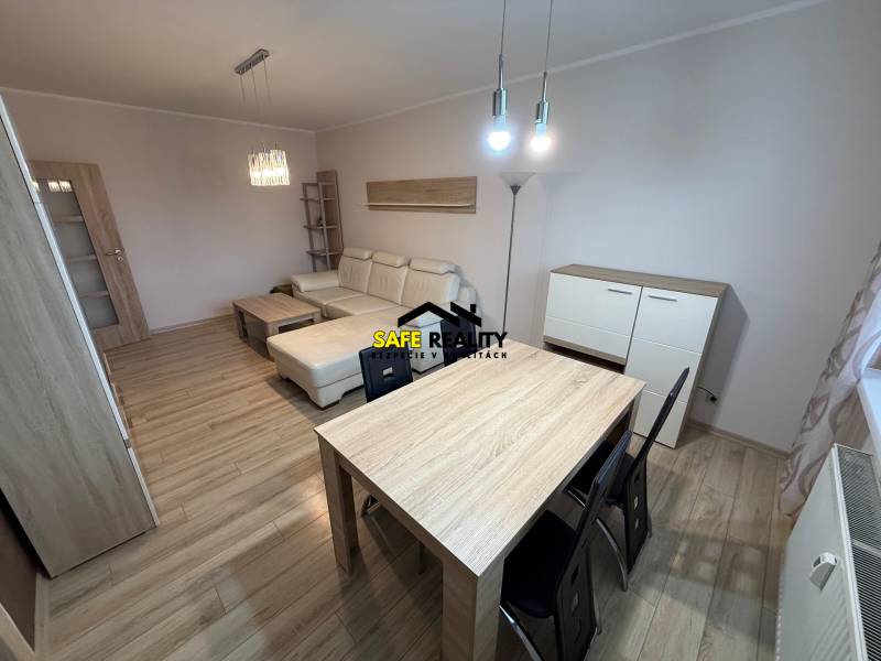 Obývací pokoj s podlahou s dřevěným dekorem, pohovkou a stolem ve 3pokojovém bytě.