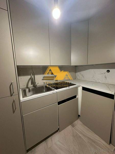 Kuchyně v 2pokojovém bytě s mramorovou deskou a šedými skříňkami.