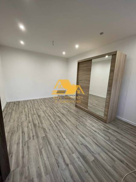 Interiér 1-pokojového bytu s podlahou s dřevěným dekorem a vestavěnou skříní.