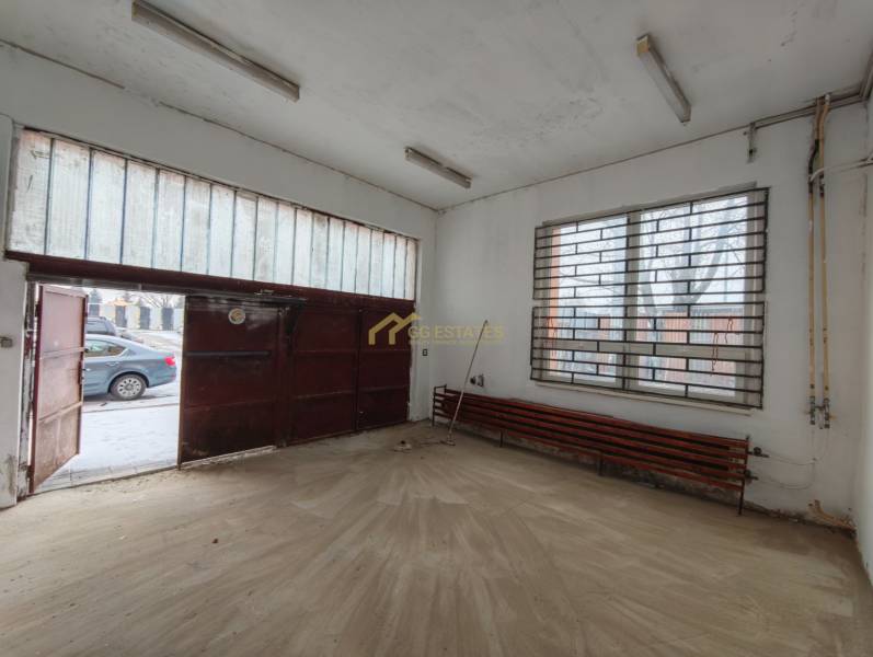 Interiér garáže s podlahou s dřevěným dekorem a kovovou bránou.