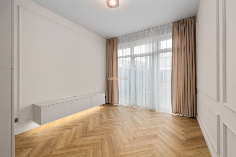 Obývací pokoj v 2pokojovém bytě s podlahou s dřevěným dekorem a bílým nábytkem.