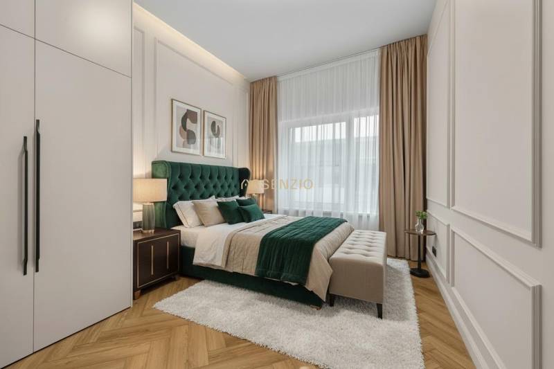 Ložnice s postelí, nočními stolky, obrázky na stěně a podlahou s dřevěným dekorem.