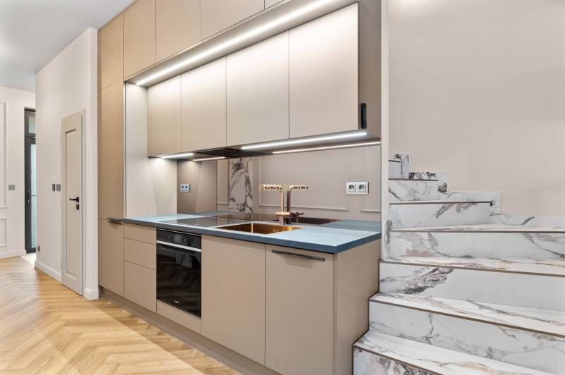 Kuchyně v 2pokojovém bytě s mramorovým schodištěm a podlahou s dřevěným dekorem.