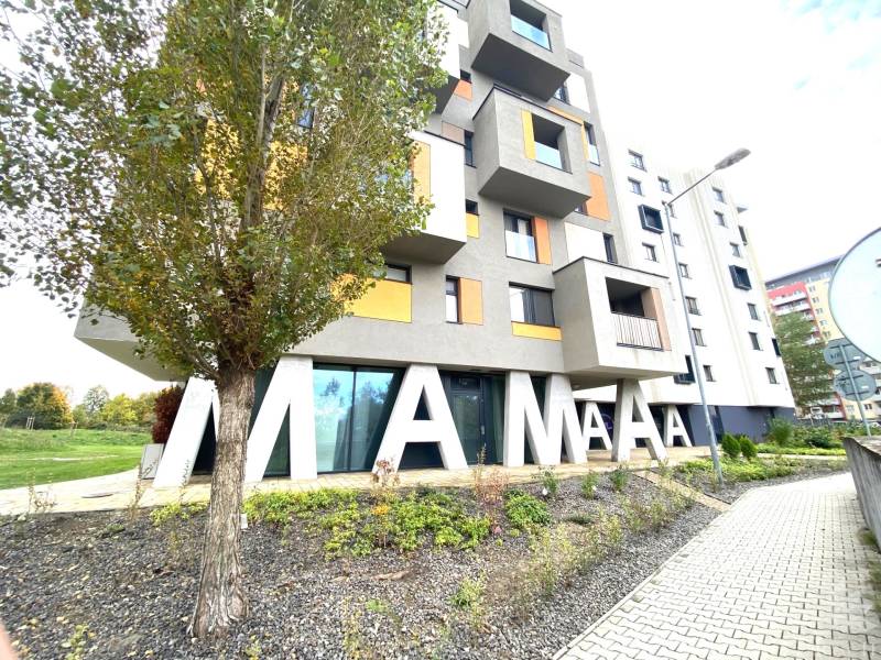 Budova s nápisem a stromem na ulici Nejedlého v Bratislavě - Dúbravce.