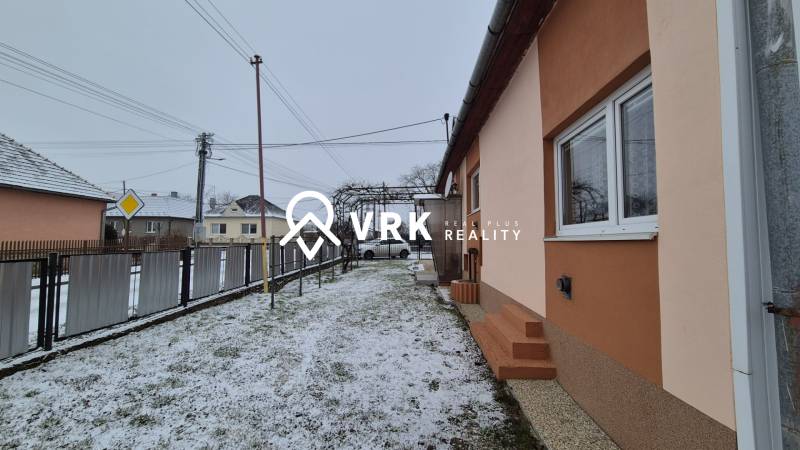 Rodinný dům na ulici Nová ve Velkých Ozorovcích se zasněženým dvorem a plotem.