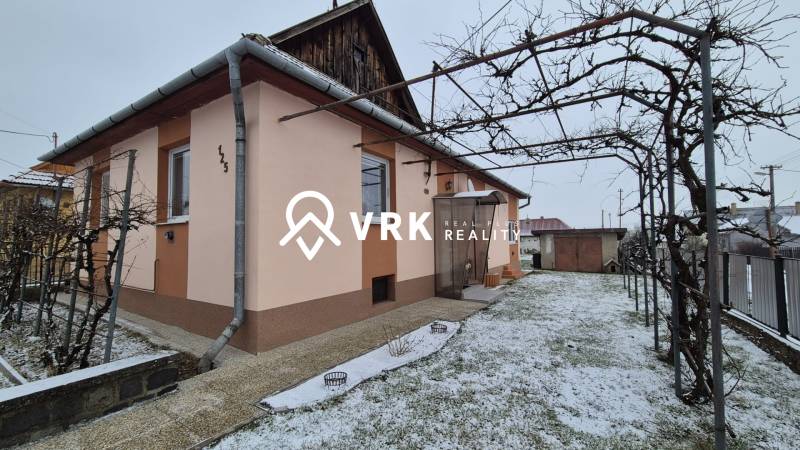 Rodinný dům na Nové ulici ve Velkých Ozorovcích s trubkovým altánkem a zasněženou zahradou.