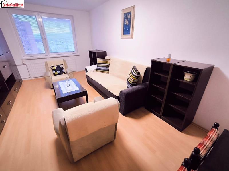 Obývací pokoj v 2pokojovém bytě s pohodlným sezením a podlahou s dřevěným dekorem.