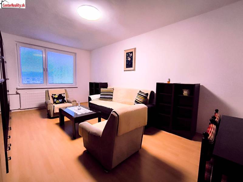 Obývací pokoj v 2-pokojovém bytě s minimalistickým nábytkem a podlahou s dřevěným dekorem.