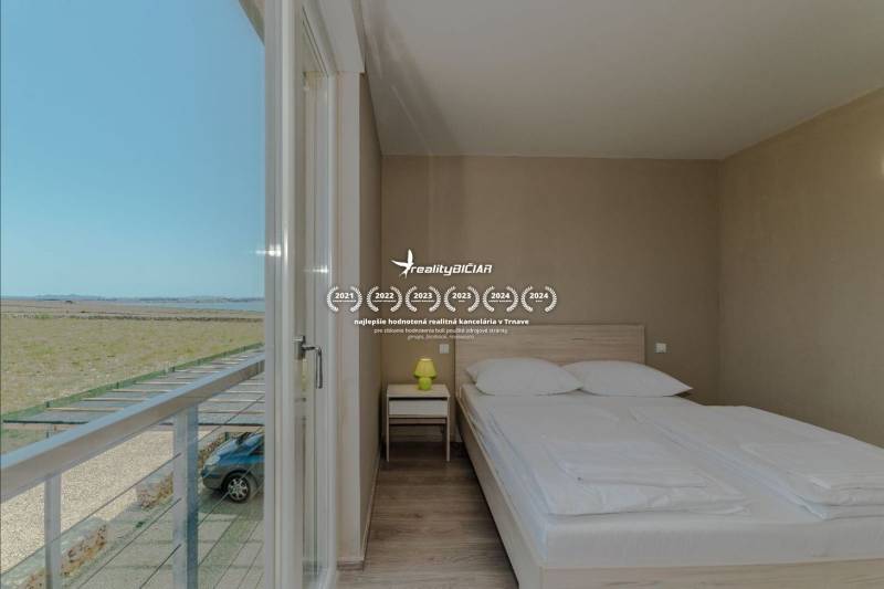 Ložnice v rekreačním apartmánu s výhledem, postelí a podlahou s dřevěným dekorem.