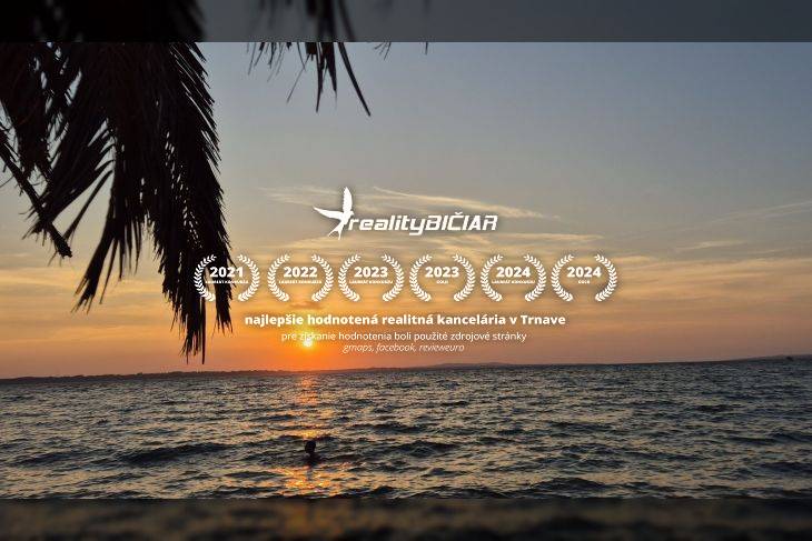 Západ slunce nad mořem, palmové listy v popředí, oceňující známky pro reality.