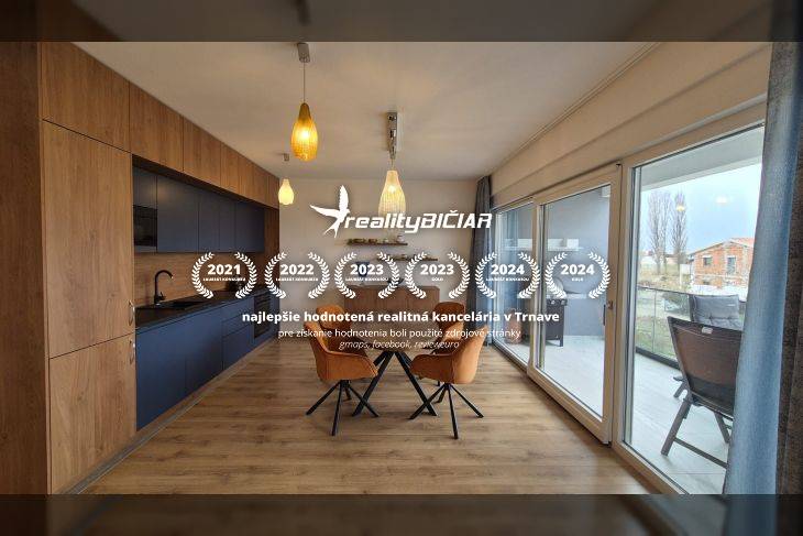 Jídelní kout s podlahou s dřevěným dekorem a velkými okny v rekreačním apartmánu.