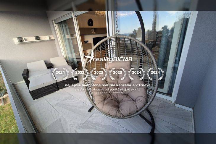 Odpočinková terasa rekreačního apartmánu s kulatým houpacím křeslem a ratanovým posezením.