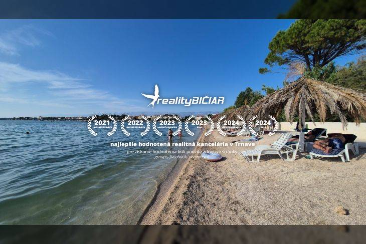 Písečná pláž u moře s lehátky pod slaměnými slunečníky, čisté nebe a klidná voda.