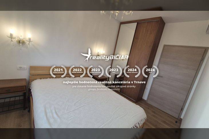 Rekreační apartmán s pohodlnou postelí a podlahou s dřevěným dekorem, osvětlený nástěnnými lampami.