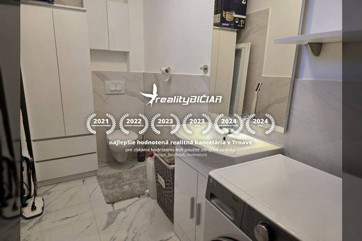 Koupelna v rekreačním apartmánu s pračkou a mramorovým dekorem stěn.