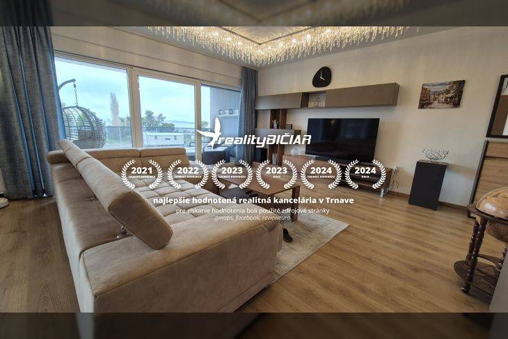 Obývací pokoj v rekreačním apartmánu s pohovkou a podlahou s dřevěným dekorem.