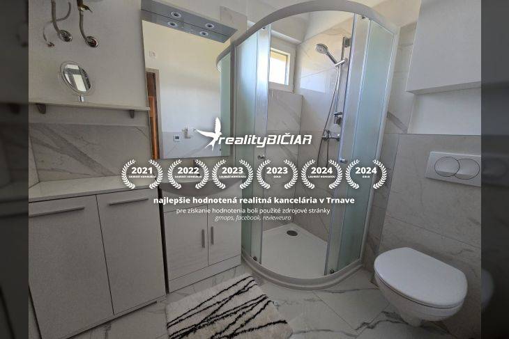 Koupelna v rekreačním apartmánu s moderním sprchovým koutem a bílým nábytkem.