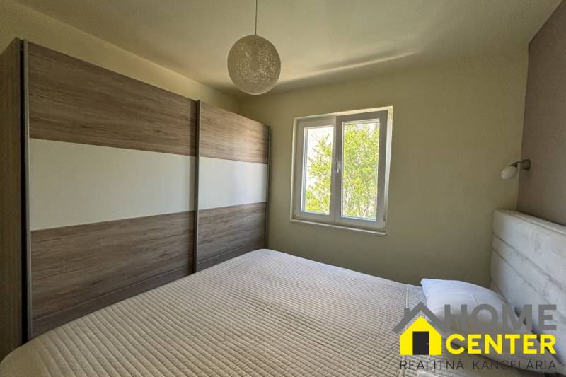 Ložnice v rodinném domě s francouzským oknem a velkou šatnou.