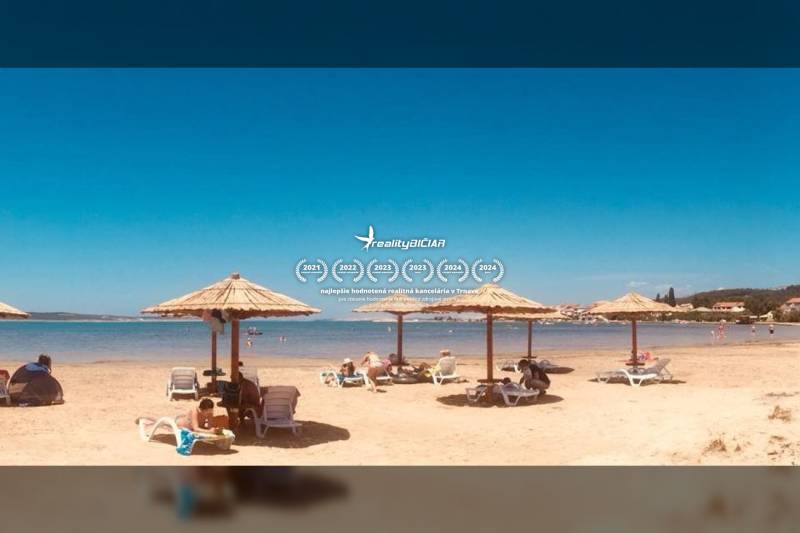 Pláž s lehátky a slunečníky u moře ve městě Ljubač na bydlení.