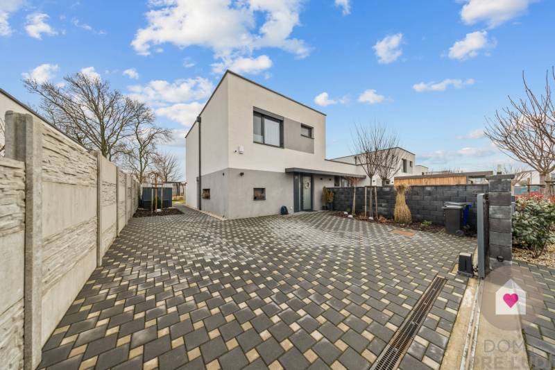 Rodinný dům na Topolové ulici v Rovince s dlážděným nádvořím a oplocením.