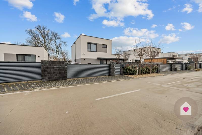 Novostavby s garáží na Topolové ulici v Rovince, obklopené moderním plotem.