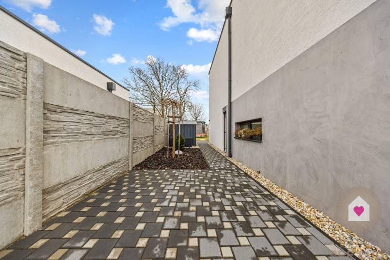 Dlázděná cesta podél domu na Topolové ulici v Rovince.