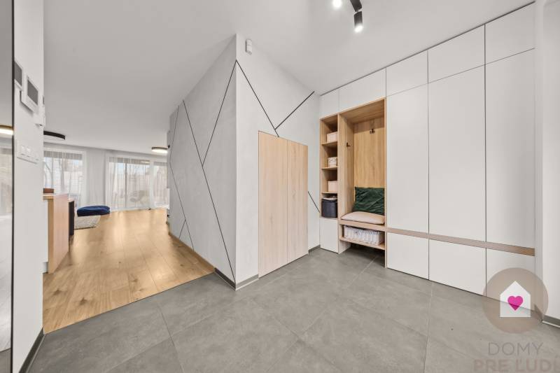 Interiér 4-pokojového bytu s podlahou s dřevěným dekorem a vestavěnými skříněmi.