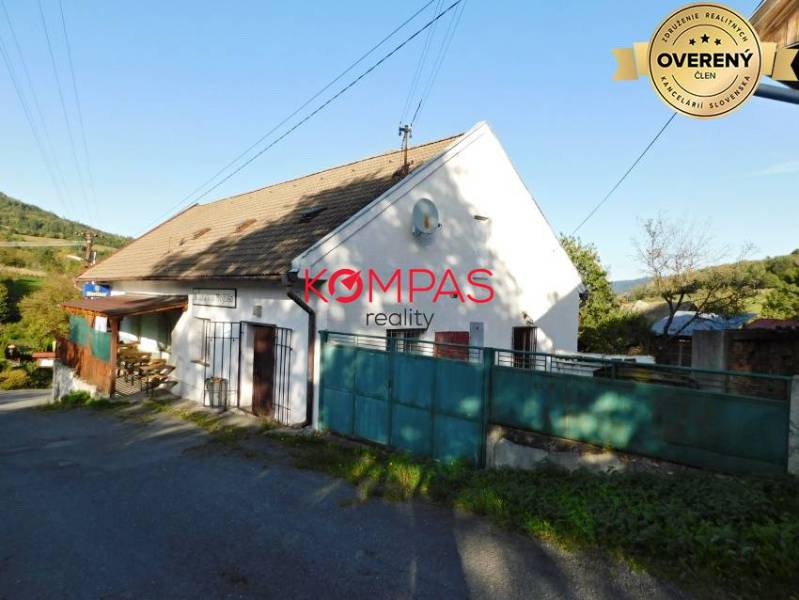 Obchodní prostory ve Vígľašské Huti-Kalince se sedlovou střechou a zpevněnou cestou.