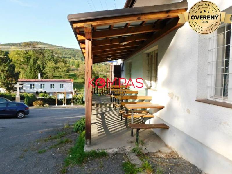 Dřevěná terasa obchodních prostor ve Vígľašské Hutě-Kalince, parkoviště, okolní příroda.