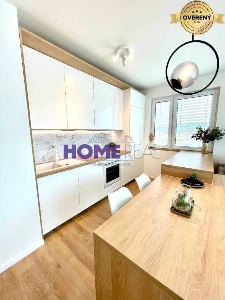 Kuchyně ve 3-pokojovém bytě s bílými skříňkami a podlahou s dřevěným dekorem.