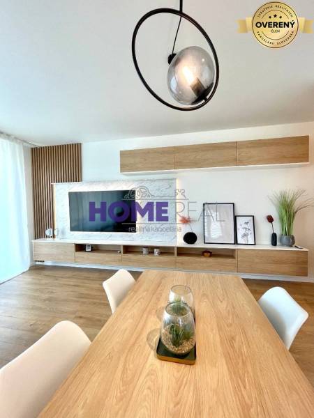 Světlý obývací pokoj ve 3-pokojovém bytě s podlahou s dřevěným dekorem a moderním liniovým osvětlením.