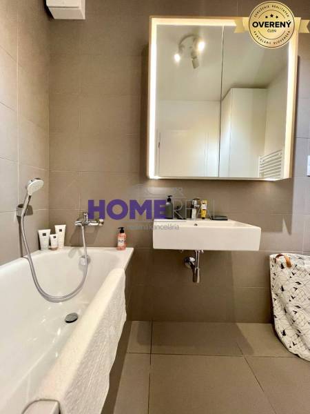 Koupelna s vanou a zrcadlem v 3-pokojovém bytě.