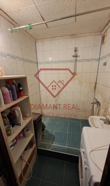 Útulná koupelna s pračkou, bílými obklady a poličkami, ideální pro 3pokojový byt.