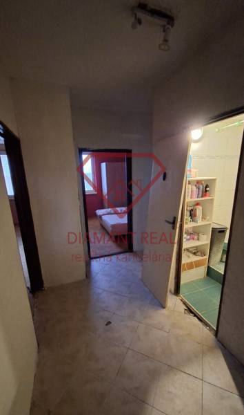 Chodba ve 3-pokojovém bytě se vstupem do koupelny a pokoje, podlaha s dřevěným dekorem.