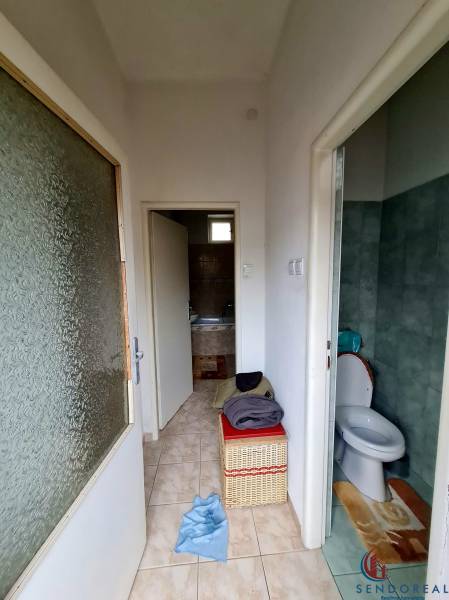 Koupelna a toaleta s dlažbou v rodinném domě, s úložným košem.