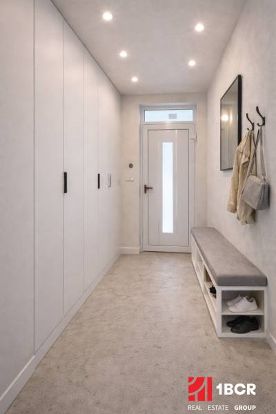 Chodba v rodinném domě s věšákem, lavicí a vestavěnou skříní.