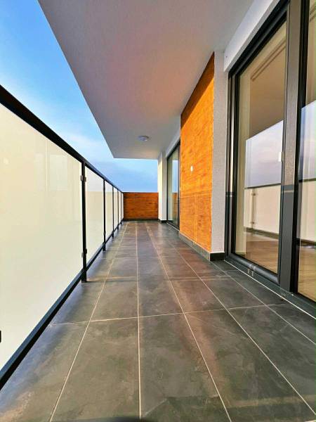 Bezpečné balkonové zábradlí a tmavá dlažba na balkóně 3pokojového bytu.