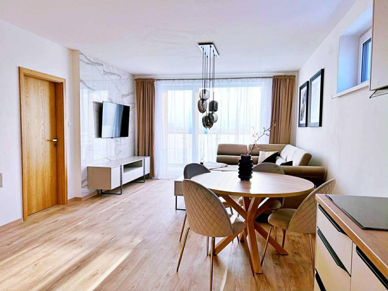 Obývací pokoj ve 3pokojovém bytě se světlým nábytkem a podlahou s dřevěným dekorem.