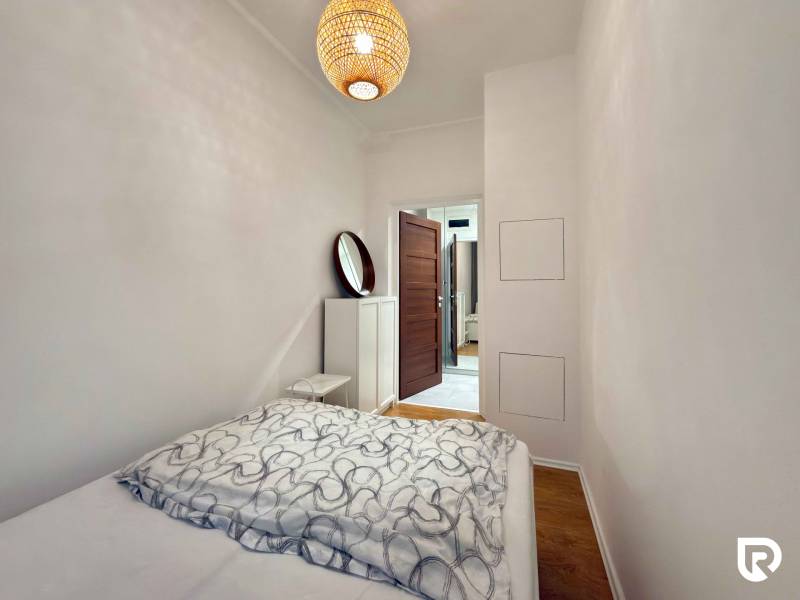 Ložnice s postelí a podlahou s dřevěným dekorem v 2-pokojovém bytě.