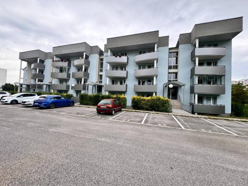 Bytový dům s šedými balkony na Halalovce v Trenčíně s parkovacími místy.