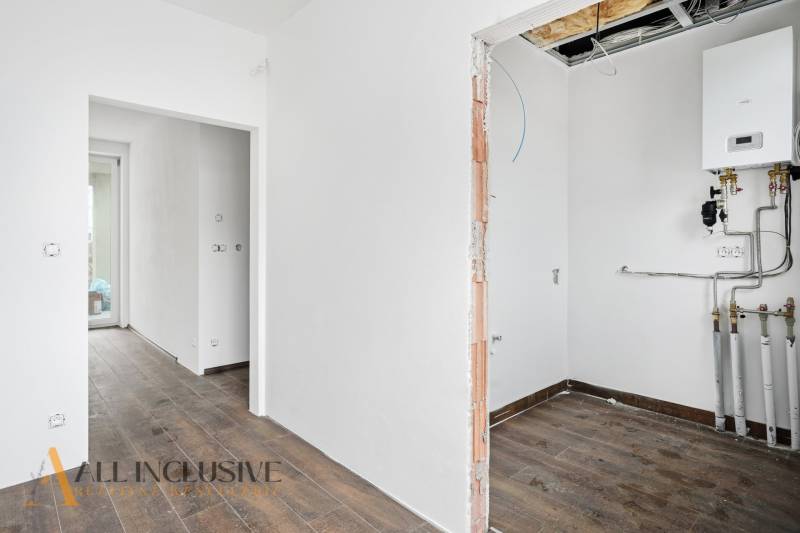 Interiér rodinného domu s podlahou s dřevěným dekorem a vytápěcím zařízením.