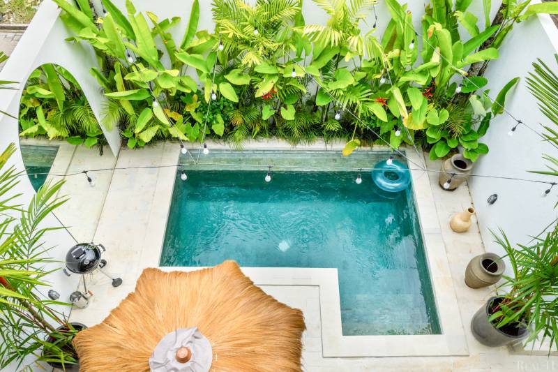 Bazén ve vile na ulici Berawa v Canggu, obklopený zelení a dekoracemi.