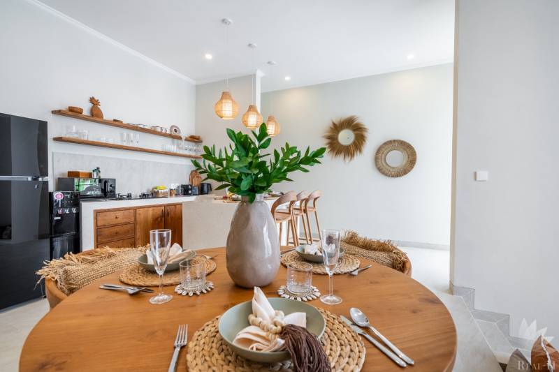 Prostřený stůl ve vile s podlahou s dřevěným dekorem a kuchyňským koutem.