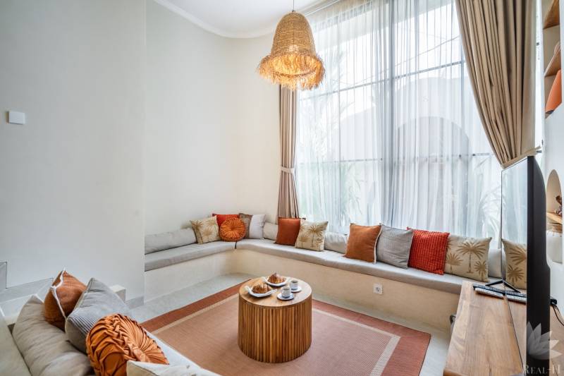 Pohodlné sezení s polštáři a dřevěným stolkem v útulném rohu vily.