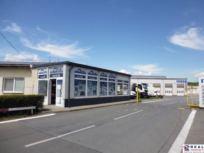 Budova s garážemi a nákladními vozidly na Strojnícké ulici v Prešově, sklady a haly.