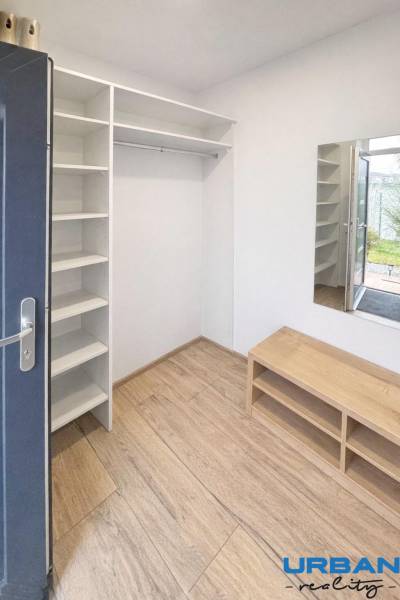 Chodba s policemi a podlahou s dřevěným dekorem v 3-pokojovém bytě.