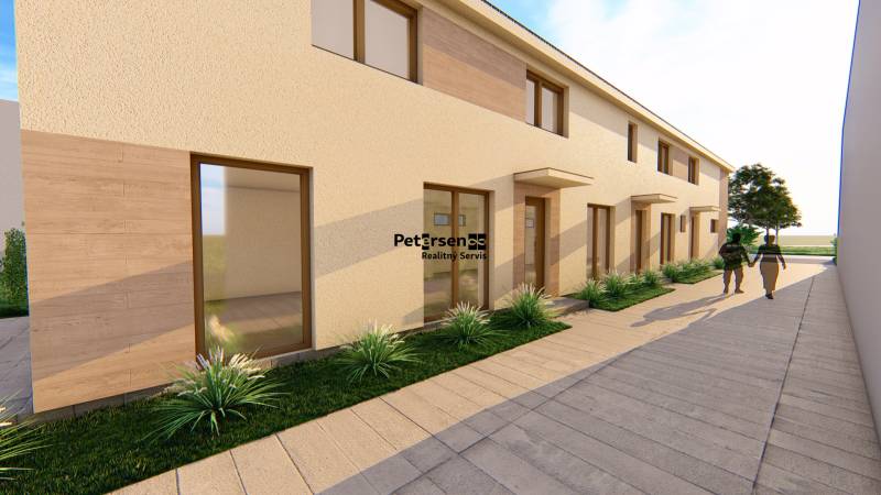 Rovná fasáda budovy s vysokými okny a chodníkem na ulici Litoměřická v Topoľčiankách.