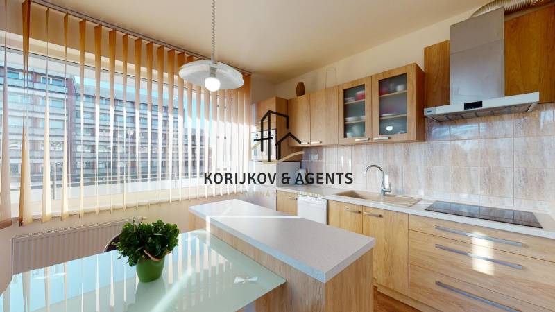 Kuchyně s podlahou s dřevěným dekorem v 2pokojovém bytě, světlé vybavení a velké okno.