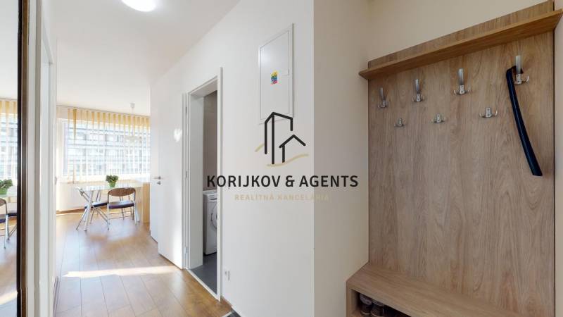 Chodba s podlahou s dřevěným dekorem a věšákem v 2-pokojovém bytě.