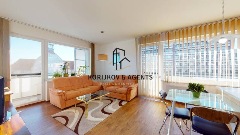 Obývací pokoj v 2-pokojovém bytě s podlahou s dřevěným dekorem a pohodlnou sedačkou.